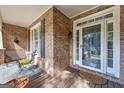 Enclosed front porch with brick columns, a seating area, and a glass front door at 770 River Cove Dr, Dacula, GA 30019