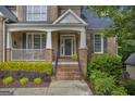 Welcoming front porch with brick steps, decorative plants, and a cozy seating area at 770 River Cove Dr, Dacula, GA 30019