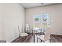 Bright dining area featuring hardwood floors and a glass table with white chairs at 600 Dairy Dr, Stockbridge, GA 30281