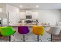 Modern kitchen island featuring stainless steel appliances, granite countertops, and colorful seating at 600 Dairy Dr, Stockbridge, GA 30281