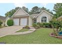 Charming single-story home with stone accents, a two-car garage and well-maintained landscaping at 323 Newfield Way, Peachtree City, GA 30269