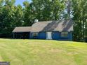 Charming blue home with a well-manicured lawn and a convenient covered carport at 105 Harris Ct, Stockbridge, GA 30281