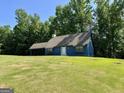 Charming blue home with a well-manicured lawn and a convenient covered carport at 105 Harris Ct, Stockbridge, GA 30281