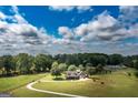 Scenic aerial view of a charming gray home surrounded by lush greenery and mature trees on a sprawling lot at 411 Hampton Rd, Fayetteville, GA 30215