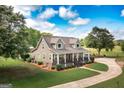 Beautiful home with well-maintained lawn, mature trees, and a charming front porch with rocking chairs at 411 Hampton Rd, Fayetteville, GA 30215