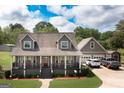 Charming gray two-story home with a welcoming front porch and well-manicured landscaping and detached garage at 411 Hampton Rd, Fayetteville, GA 30215