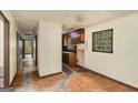 Hallway leads to a kitchen with wood cabinets and a window view at 6109 Oakwood Sw Cir, Covington, GA 30014