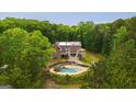 Aerial shot of a brick home with a pool surrounded by lush trees, offering privacy and tranquility at 1212 Lee Whatley Dr, Lithonia, GA 30058