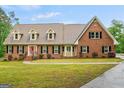 Charming brick home featuring well-manicured lawn, dormer windows, and classic shutters at 1212 Lee Whatley Dr, Lithonia, GA 30058