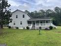 Spacious backyard featuring a lush green lawn and a charming two-story home with a covered porch at 1125 Babbs Mill Rd, Hampton, GA 30228