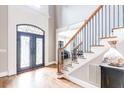 Elegant entryway featuring hardwood floors, a decorative iron front door, and a staircase with wooden banister at 4090 Cooks Farm Nw Dr, Kennesaw, GA 30152