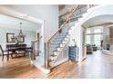 Spacious entryway with hardwood floors, a staircase with iron railings, and open views to the dining and living areas at 4090 Cooks Farm Nw Dr, Kennesaw, GA 30152