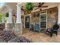 Close-up of stone porch with ceiling fans, columns, and outdoor seating at 2294 Hollonville Rd, Brooks, GA 30205
