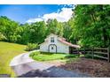 Quaint two-story home with a red roof and lush greenery, nestled in a serene wooded setting at 3258 South Mckoy Rd, Villa Rica, GA 30180