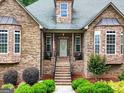 Inviting front porch with brick steps, lovely landscaping, and stone accents at 124 Belford Way, Locust Grove, GA 30248