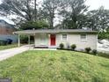 Inviting single-story home featuring a bright red front door and a convenient carport at 438 Fedora Nw Way, Atlanta, GA 30331