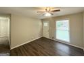 Cozy living room featuring hardwood floors, neutral paint, and plenty of natural light through the window at 438 Fedora Nw Way, Atlanta, GA 30331