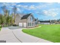 A three-car garage and a driveway lead to this home's welcoming facade at 92 Gordon Oaks Way, Moreland, GA 30259