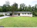 Charming single-story home featuring a spacious front lawn and a convenient covered carport at 1889 Silver Creek Dr, Austell, GA 30168