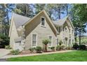 Low angle showing stucco home with front facing garage, complemented by lush green lawn and landscaping at 121 Tamerlane, Peachtree City, GA 30269