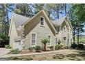 Stunning exterior view showcasing neutral stucco, white trim and a spacious three car garage at 121 Tamerlane, Peachtree City, GA 30269