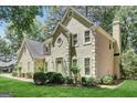 Side view of a home with an attached garage, stucco exterior, and manicured landscaping at 121 Tamerlane, Peachtree City, GA 30269