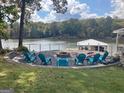 Lakeside backyard featuring a stone fire pit and plenty of Adirondack chairs for entertaining at 22 Waters Bridge Cir, Covington, GA 30014