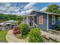 Inviting blue home with a covered porch and landscaped walkway leading to a cozy gazebo at 22 Waters Bridge Cir, Covington, GA 30014