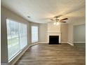 Spacious living room featuring wood floors, a fireplace, and bright natural lighting at 4467 Thornwood Cres, Stone Mountain, GA 30083