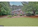 Charming brick home featuring lush landscaping and a well-manicured front yard at 120 Hamilton Glen Ct, Fayetteville, GA 30215