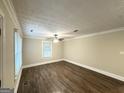 An empty bedroom showcasing sleek, dark wood-look floors, neutral walls, and updated ceiling fan at 4162 Mercer Rd, Decatur, GA 30035