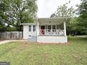 Charming painted brick home featuring a covered front porch and a well-manicured lawn at 4162 Mercer Rd, Decatur, GA 30035