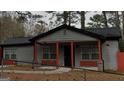 Close up of the exterior of a single-story home with grey siding and red accent columns at 3479 Thompson Nw Dr, Atlanta, GA 30331