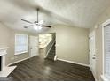 Bright living room featuring a staircase, hardwood floors, and access to the kitchen at 9151 Jefferson Village Sw Dr, Covington, GA 30014