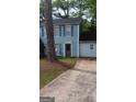 Charming two-story home with blue siding, dark shutters, and a paved driveway at 4981 Millstone Walk, Stone Mountain, GA 30088