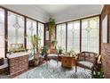 Bright sunroom with brick walls, decorative windows, and lots of plants at 239 Kings Hwy, Decatur, GA 30030