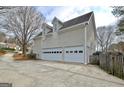 Spacious three-car garage with white doors and dormer windows, ideal for ample parking and storage at 112 Windalier Rdg, Peachtree City, GA 30269