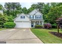 Inviting two-story home featuring a lush front lawn, charming landscaping, and a convenient two-car garage at 2022 Maple Ridge, Acworth, GA 30101