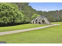 An estate home featuring a long winding driveway framed by mature trees and verdant landscaping at 391 Massengale Rd, Brooks, GA 30205