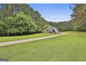 Beautiful home on lush green lawn; long driveway leads to trees and greenery at 391 Massengale Rd, Brooks, GA 30205