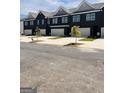 Row of modern townhomes featuring black brick facade, integrated garage, and newly planted landscaping along street at 216 Epping Drive, Stockbridge, GA 30281
