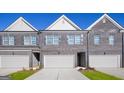 Up close view of townhomes with brick and gray siding, white trim, and attached garages at 240 Epping Dr, Stockbridge, GA 30281