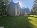 View of the home showcasing a manicured lawn with lush surrounding landscape and inviting natural light at 150 Park Timbers Drive, Sharpsburg, GA 30277