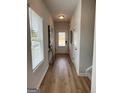 Bright hallway features wood-look floors, modern decor, and a clear view to the front door with natural light coming through the window at 256 Epping Drive, Stockbridge, GA 30281