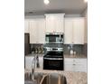Modern kitchen design with white cabinets, stainless steel appliances, granite countertops, and stylish gray subway tile backsplash at 256 Epping Drive, Stockbridge, GA 30281