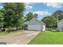 View of light blue home with a large two car garage on a cracked driveway with small front lawn at 1152 Sunday Ln, Jonesboro, GA 30238