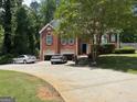 Traditional two story brick home with attached garage on a sunny day; driveway has parking at 2828 Hicks Sw Rd, Marietta, GA 30060