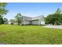 Expansive backyard featuring a lush lawn and mature trees, providing ample space for outdoor activities and relaxation at 106 June Ct, Hampton, GA 30228