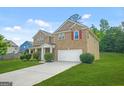 Traditional two-story home featuring a brick facade, attached garage, and a green lawn at 6533 Waterford Sw St, Atlanta, GA 30331