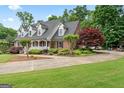 A brick home with meticulous landscaping, accentuated by a side-entry driveway and lush, mature trees at 510 Jenna Trl, Mcdonough, GA 30252